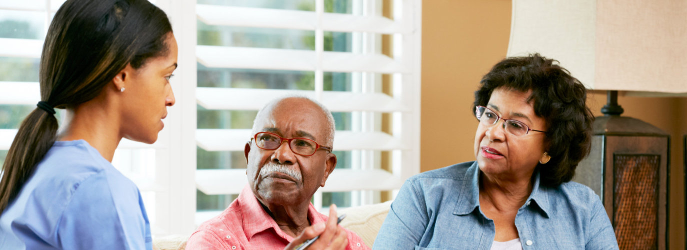 senior couple listening to a caregiver